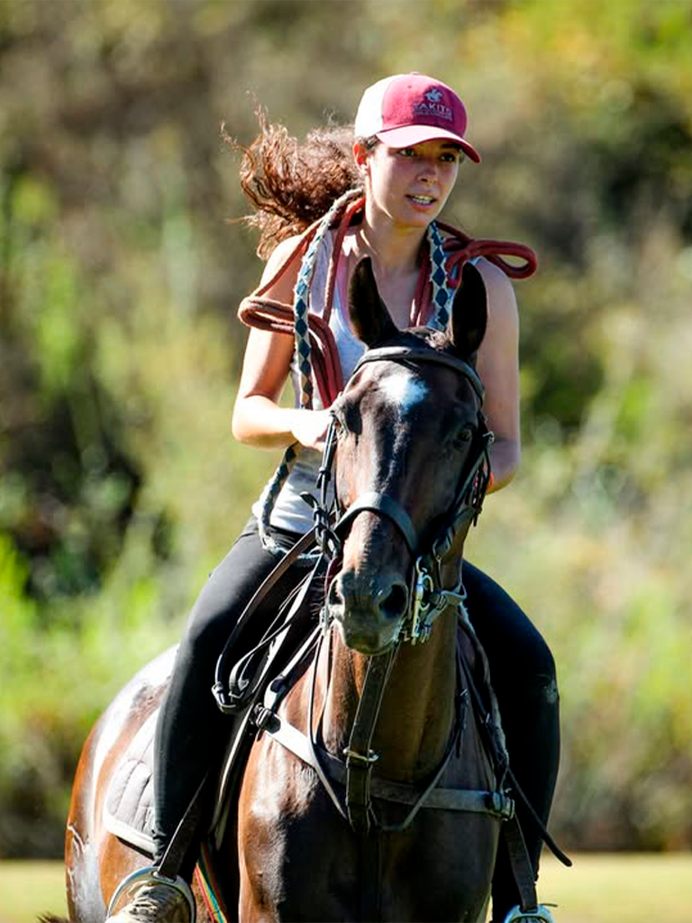 Chica montando caballo partido polo
